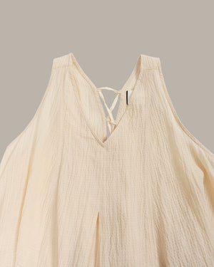 Beige top with thin straps on a neutral background
