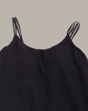 Black dress with thin straps on a beige background