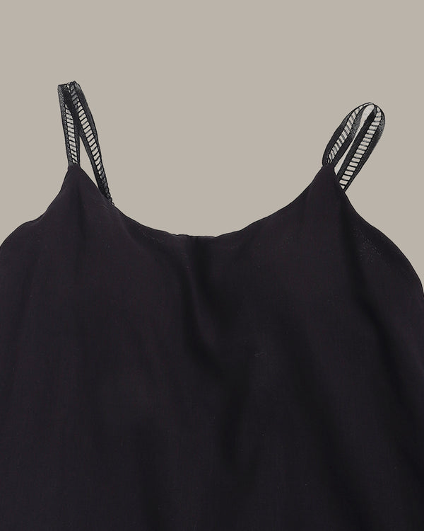 Black dress with thin straps on a beige background
