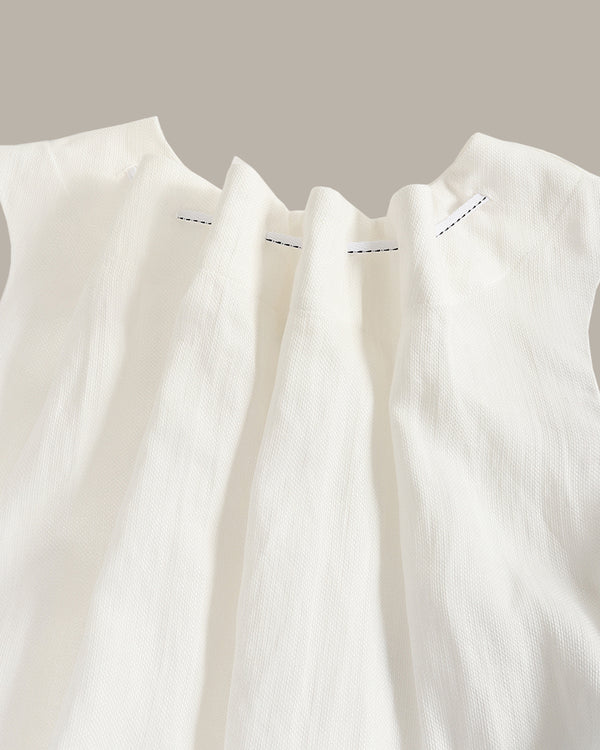 Close-up of a white sleeveless top with subtle stitching detail on a neutral background