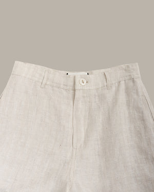 Close-up of beige pants with a button on a neutral background