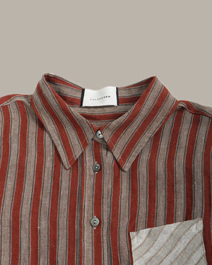 Close-up of a striped shirt with a brand label on a beige background
