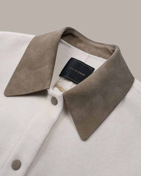 Close-up of a coat collar with a taupe suede-like outer collar and a cream-colored body, featuring a black brand label that reads 'CLODE CHEN'.