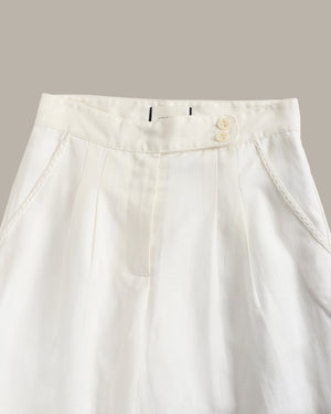 Close-up of a white pants with a button and zipper on a light gray background
