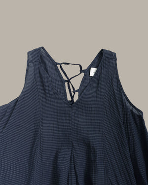 Navy blue sleeveless top with thin straps on a beige background