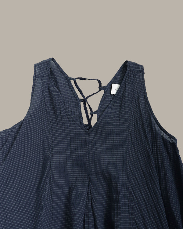 Navy blue sleeveless top with thin straps on a beige background