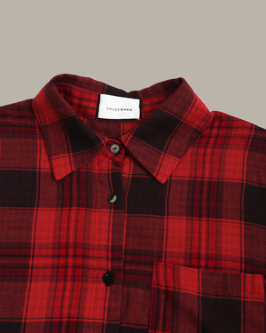 Red and black plaid shirt with collar and buttons on a neutral background