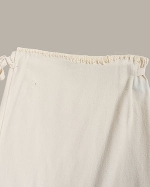Close-up of a white drawstring skirt on a light gray background