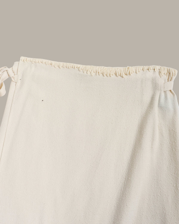 Close-up of a white drawstring skirt on a light gray background
