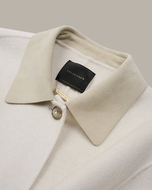 Close-up of a cream-colored wool coat collar with a black brand label reading CHLOE CHEN.