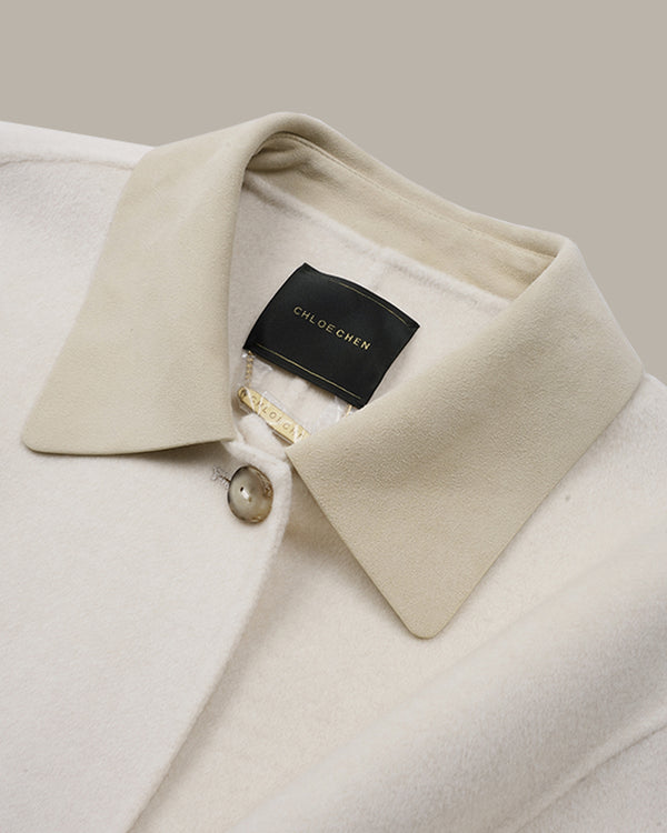 Close-up of a cream-colored wool coat collar with a black brand label reading CHLOE CHEN.
