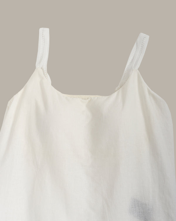 White tank top against a beige background
