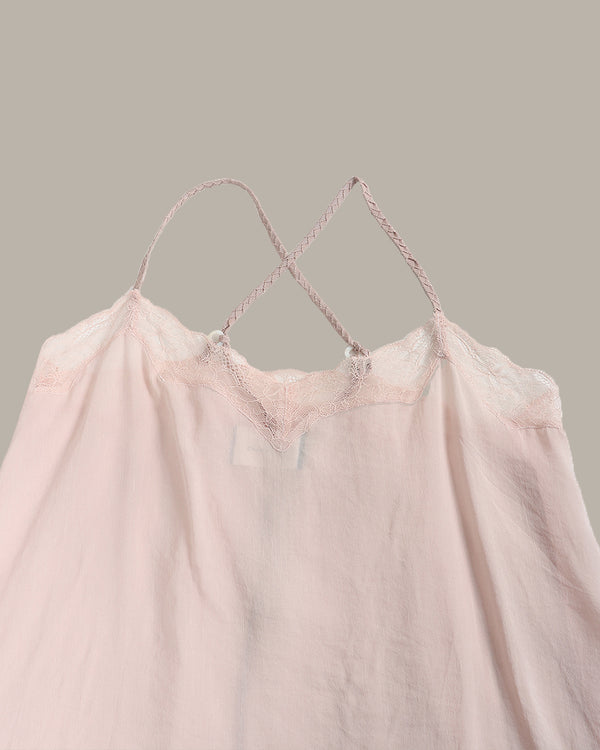 A pale pink sheer camisole top with delicate lace trim and thin braided shoulder straps, shown against a solid taupe background.