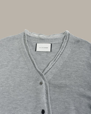 Gray cardigan with brand label on a beige background