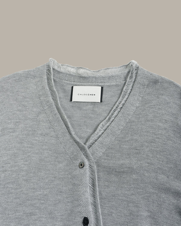 Gray cardigan with brand label on a beige background