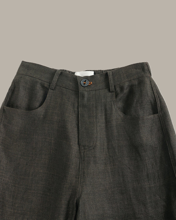 Dark gray pants with a button on a neutral background