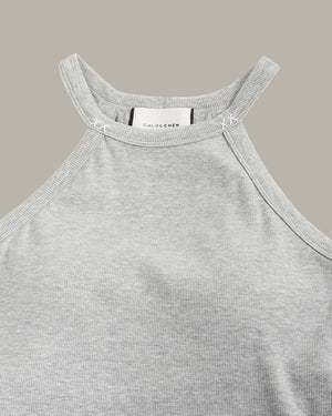 Gray tank top with a brand label on a beige background