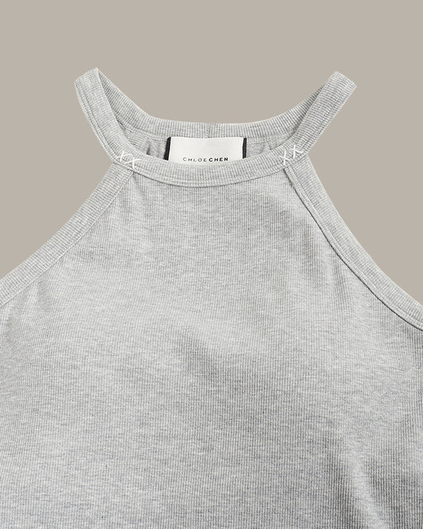 Gray tank top with a brand label on a beige background