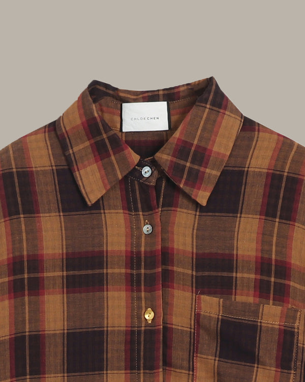 Plaid shirt with a visible brand label on a beige background
