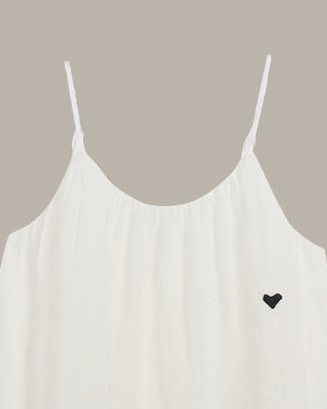 White spaghetti strap top with a black heart detail on a neutral background