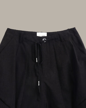 Black pants with drawstring waist on a neutral background