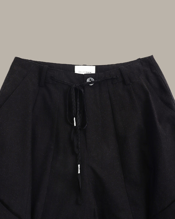 Black pants with drawstring waist on a neutral background