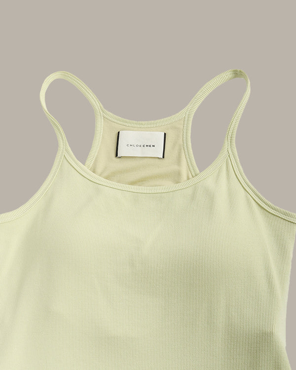 Light green tank top with thin straps on a gray background