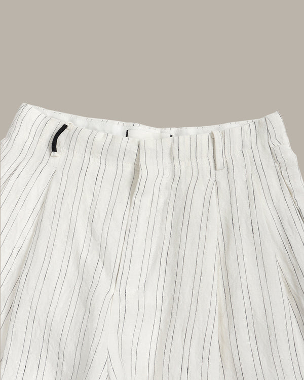 White pants with thin black stripes on a beige background