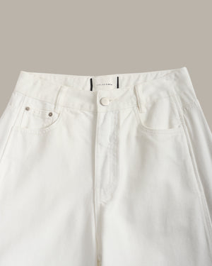 Close-up of a pair of white high-waisted denim jeans, showing the waistband, button closure, belt loops, and front pockets against a solid beige background.