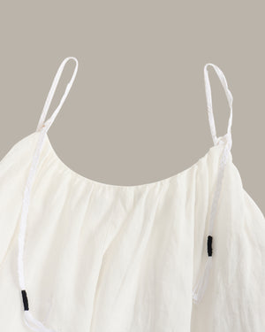 White strappy top on a beige background