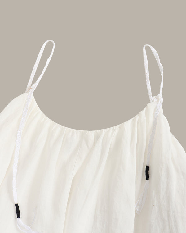 White strappy top on a beige background