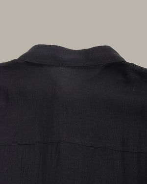 Close-up of a black shirt collar on a neutral background