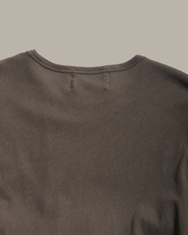 Close-up of the back of a dark brown crewneck t-shirt, showing the fabric texture and stitching details against a solid neutral background.