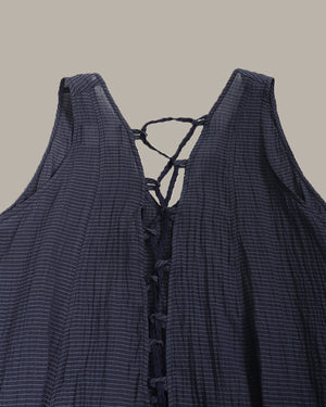 Navy blue sleeveless top with lace-up detail on a beige background
