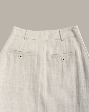 Close-up of light gray pants with a subtle pattern on a neutral background