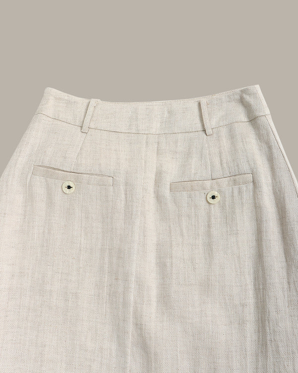 Close-up of light gray pants with a subtle pattern on a neutral background