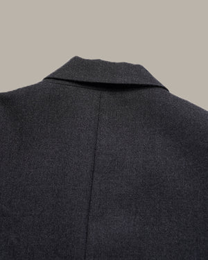 Close-up of the back collar and upper back of a dark charcoal gray wool-blend coat against a solid light gray background.