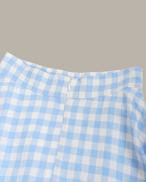 Close-up of a blue and white checkered fabric with a zipper on a gray background
