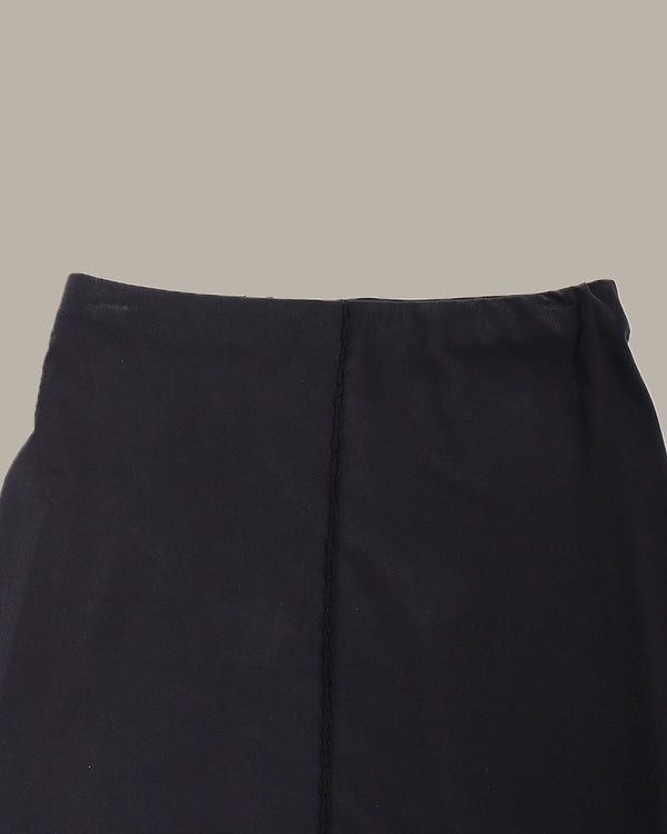 Close-up of a dark gray skirt on a beige background