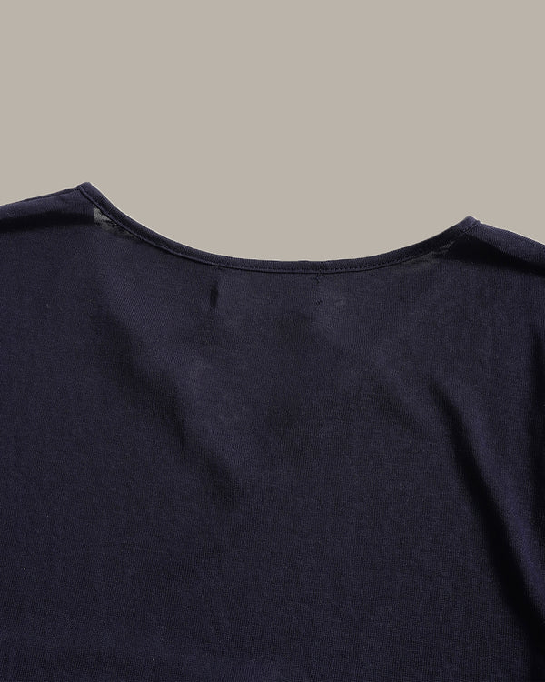 Close-up of the back neckline of a dark navy blue knit top against a solid light gray background.
