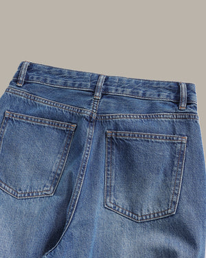Close-up of blue jeans with a gray background