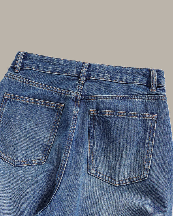 Close-up of blue jeans with a gray background