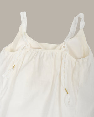 White top with thin straps on a beige background