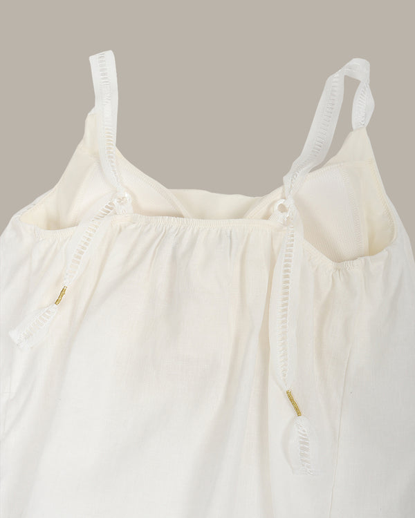 White top with thin straps on a beige background