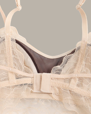 Beige lace bra on a gray background