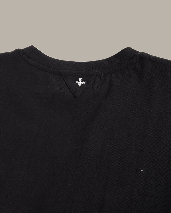 Close-up of a black garment with a brand logo on a neutral background