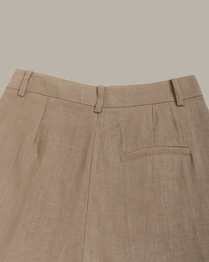 Close-up of the back of brown shorts with a pocket on a neutral background