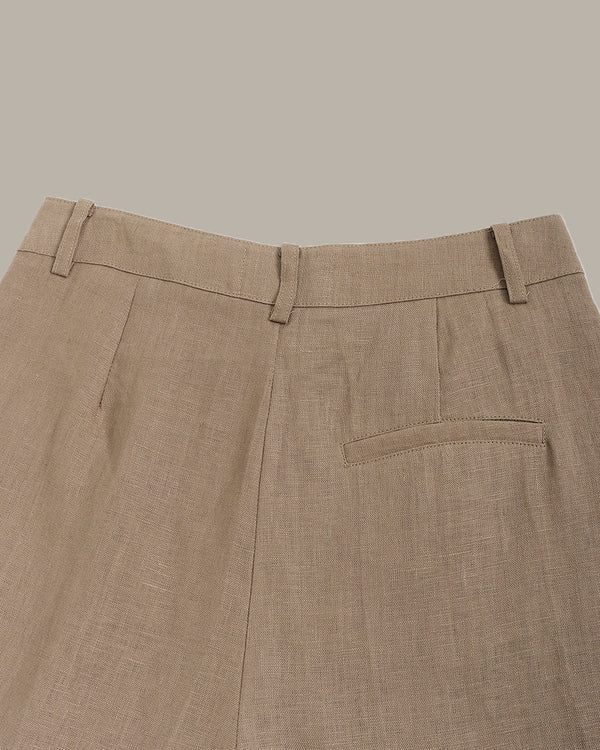 Close-up of the back of brown shorts with a pocket on a neutral background