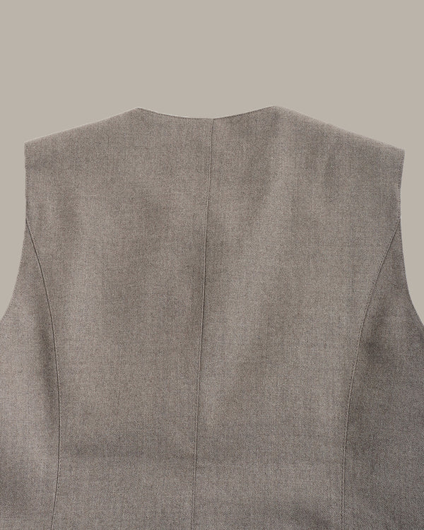 Close-up of the back of a sleeveless gray vest or waistcoat, showing a fine textured fabric and a centered seam, on a plain taupe background.
