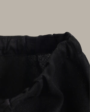 Close-up of black skirt on a beige background